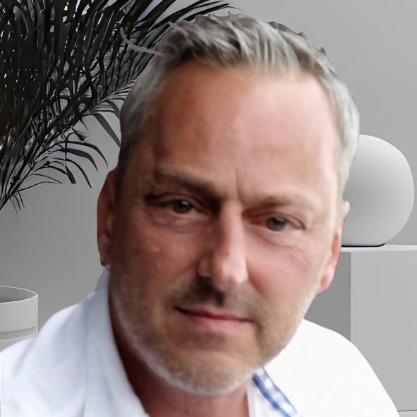 Porträt eines Mannes mit grauen Haaren und einem lässigen weißen Hemd. Bei diesem Mann handelt es sich um den Romanautor H. J. Kohlhofer